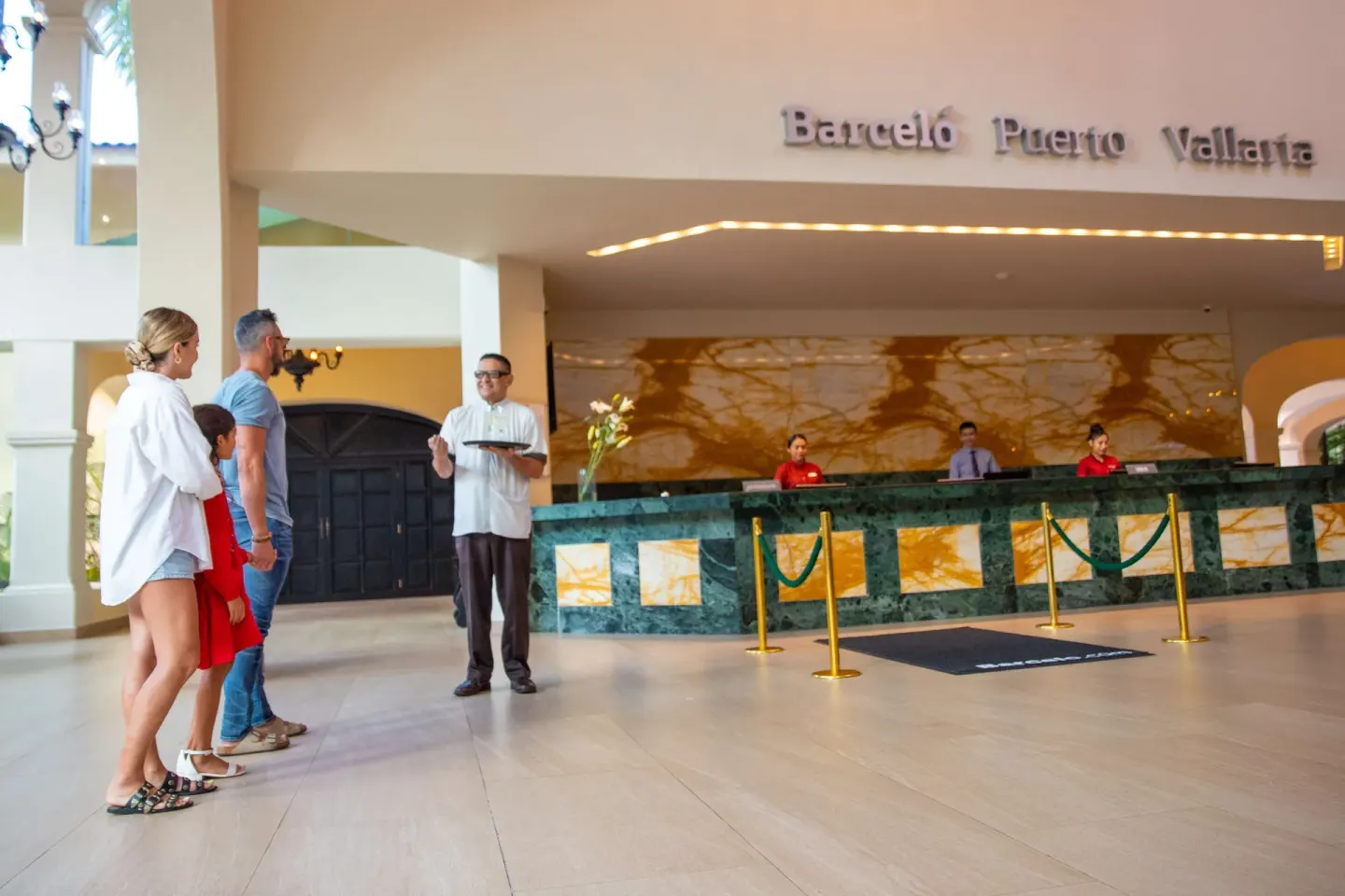 Guests meet staff at the reception desk in the lobby of Barceló Puerto Vallarta.