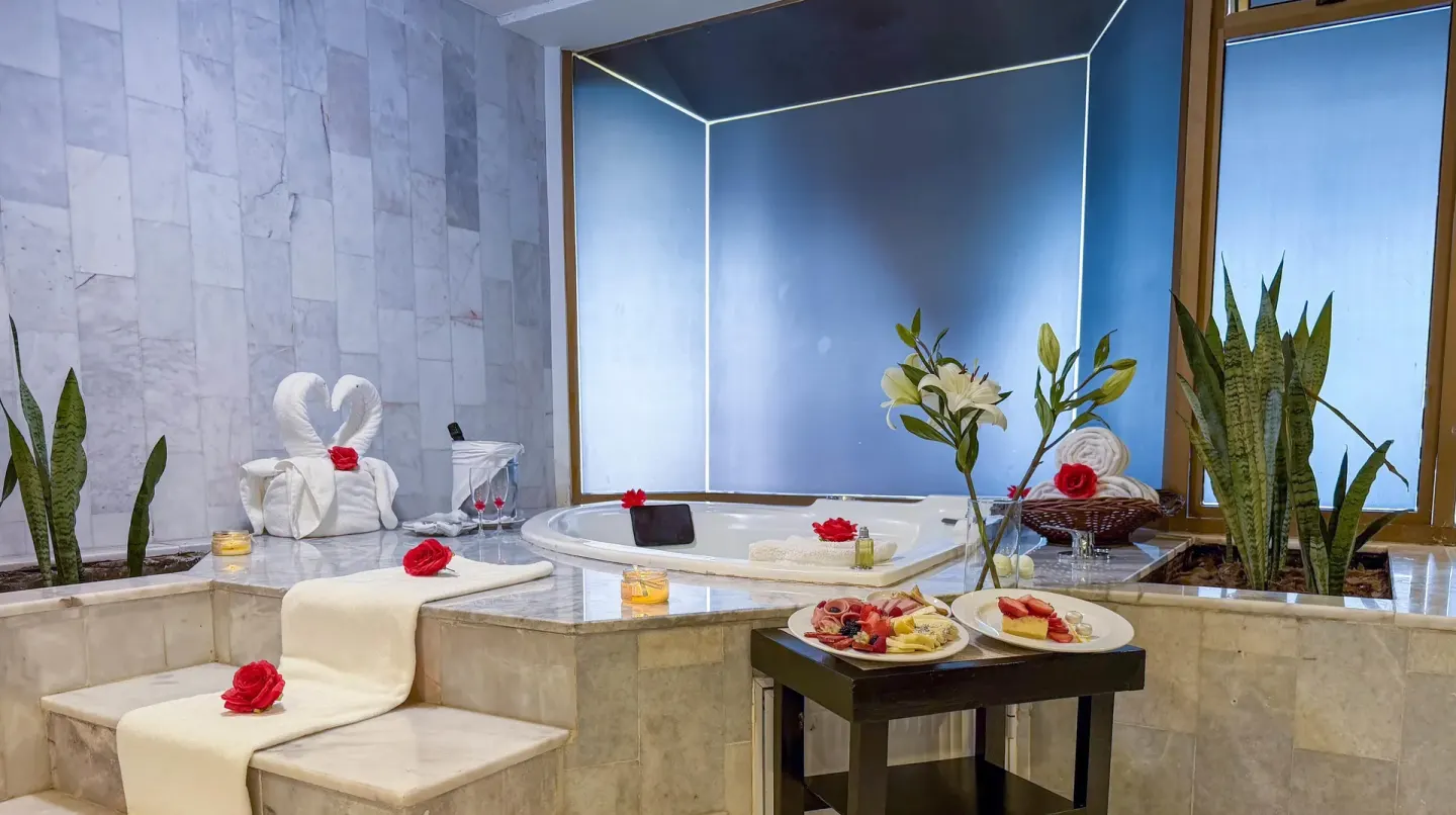 Spa bath setup with candles, flowers, towels, and fruit at Barceló Puerto Vallarta.