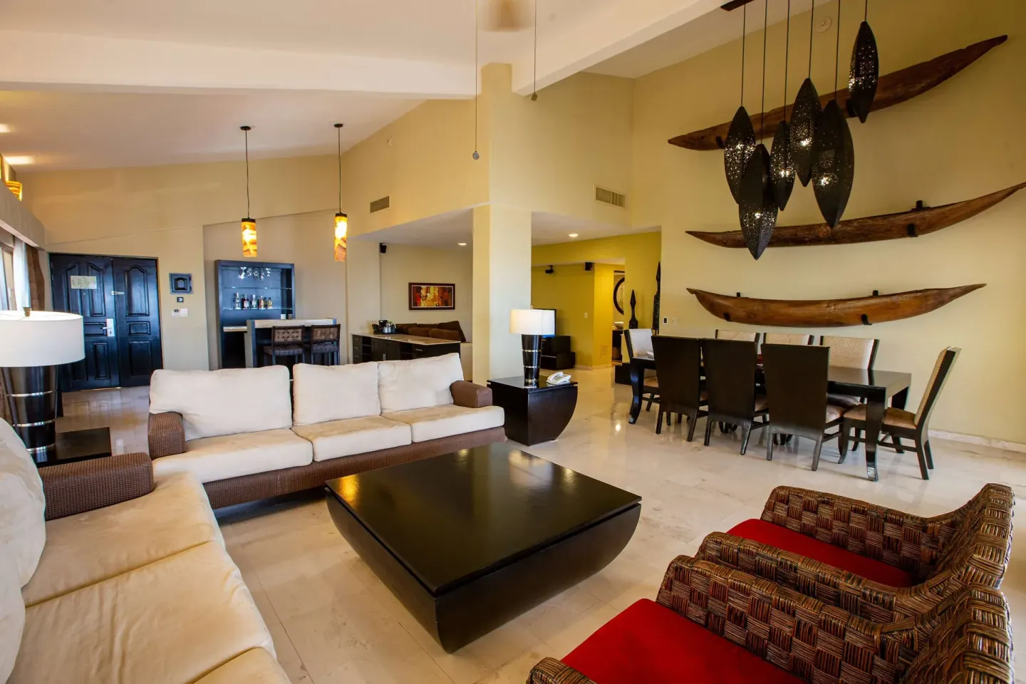 A large suite living and dining area with sofas and canoe wall décor at Barceló Puerto Vallarta.