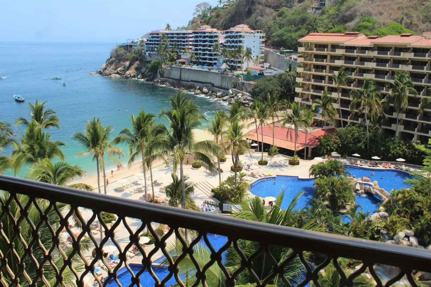 Balcony view of beach, pools and bay from a Deluxe Suite at Barceló Puerto Vallarta.