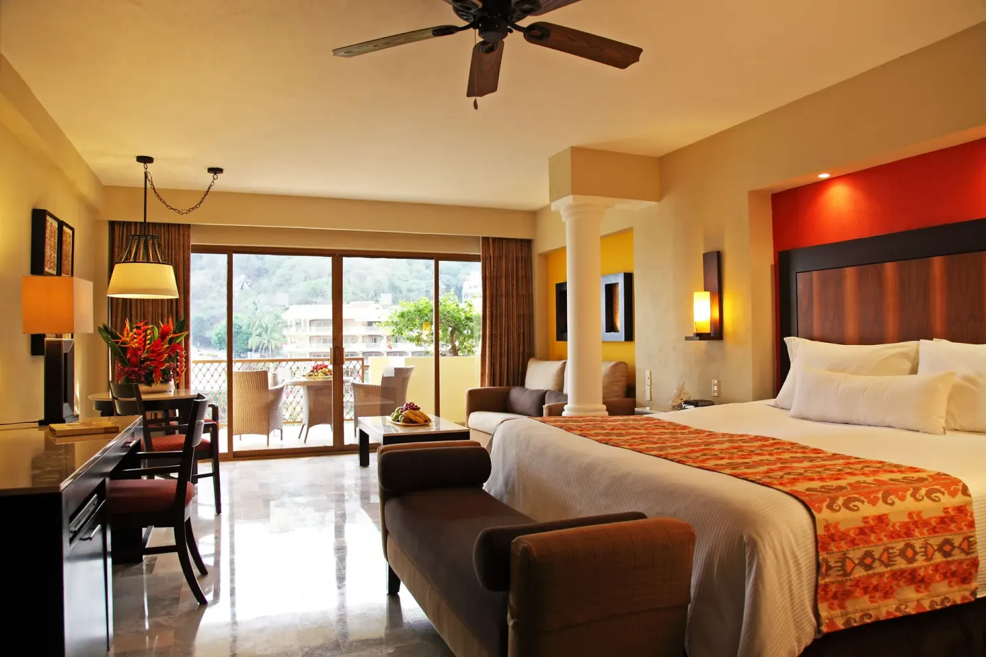 Deluxe Suite king bed, sitting area and balcony at Barceló Puerto Vallarta.