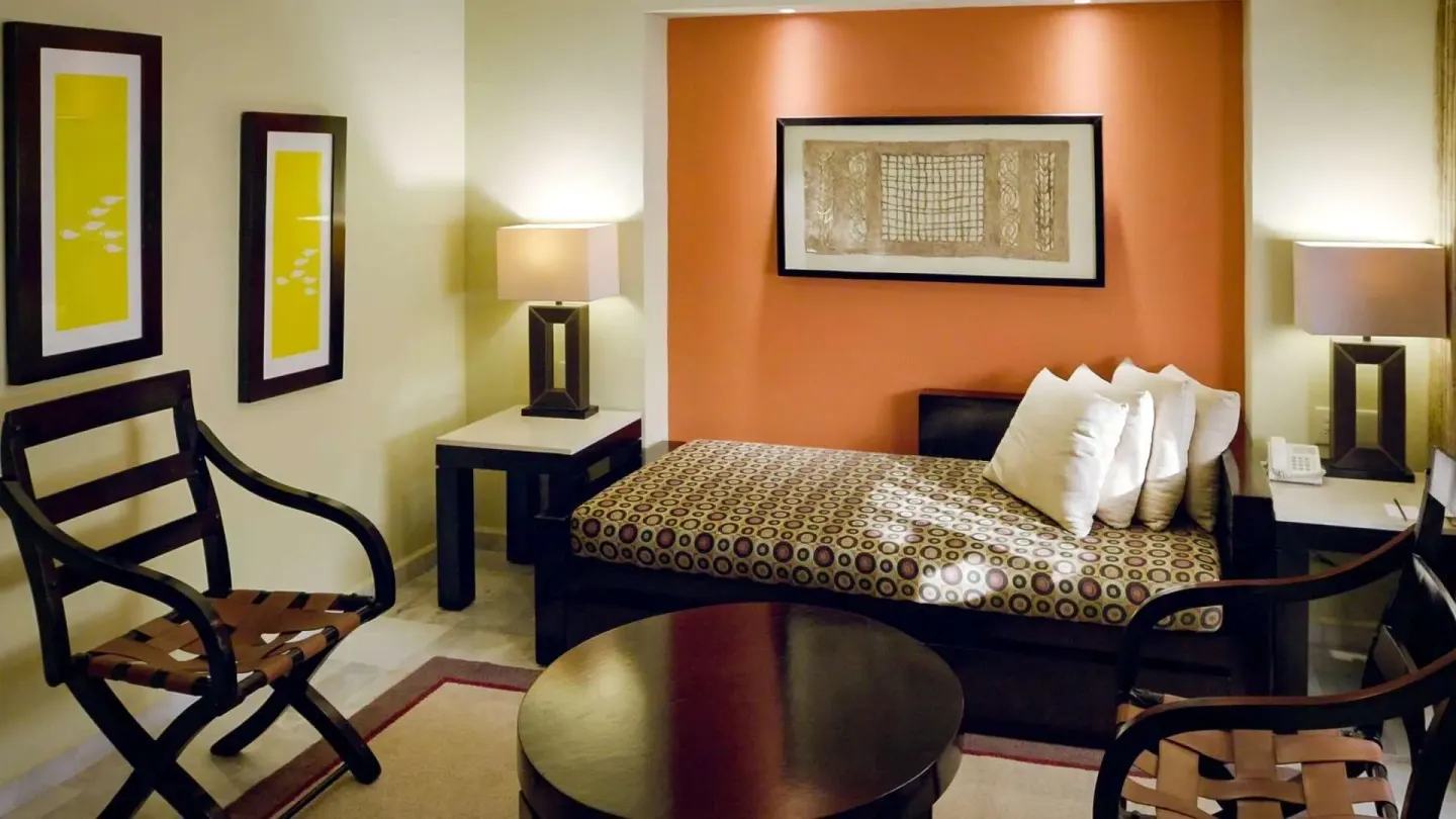Deluxe Suite lounge area with daybed, chairs and round table at Barceló Puerto Vallarta.