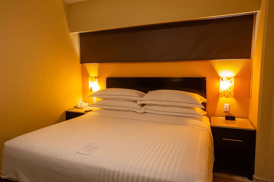 Family Room Premium Level bed with warm bedside lighting at Barceló Puerto Vallarta.