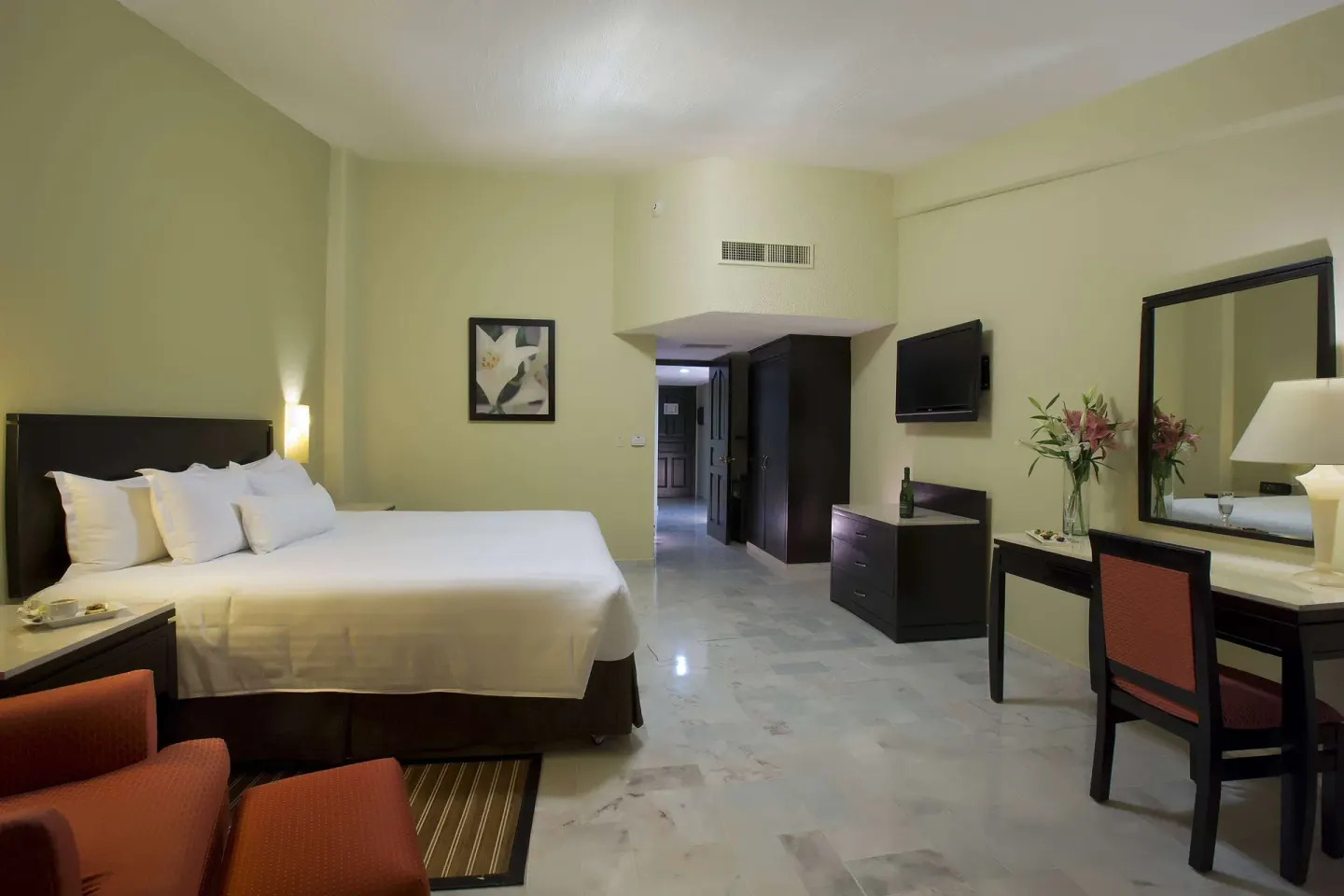 Family Room Premium Level with king bed, dresser, desk, and mirror at Barceló Puerto Vallarta.