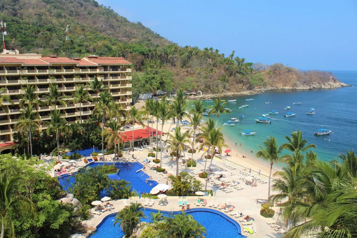 Family Room elevated view of pools, beach, bay, and hillside at Barceló Puerto Vallarta.