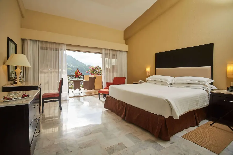Family Room king bed with balcony seating visible at Barceló Puerto Vallarta.