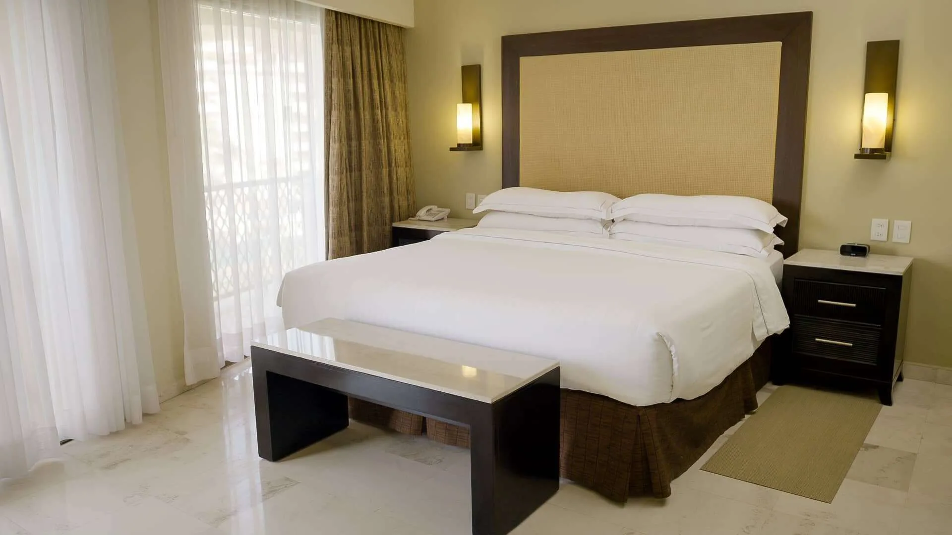 Grand Master Suite king bedroom with white bedding at Barceló Puerto Vallarta.