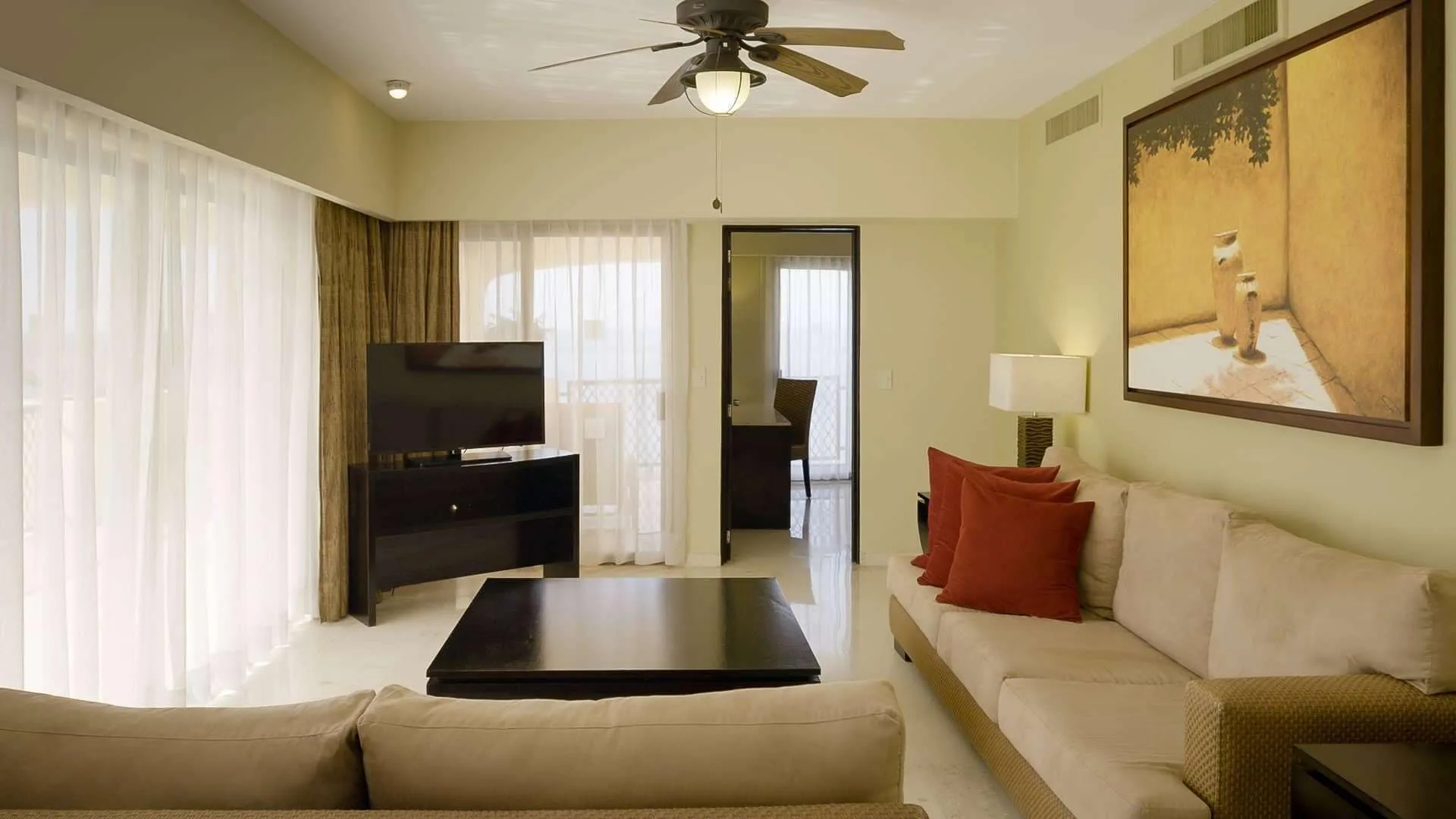 Grand Master Suite living room with sofas and TV at Barceló Puerto Vallarta.