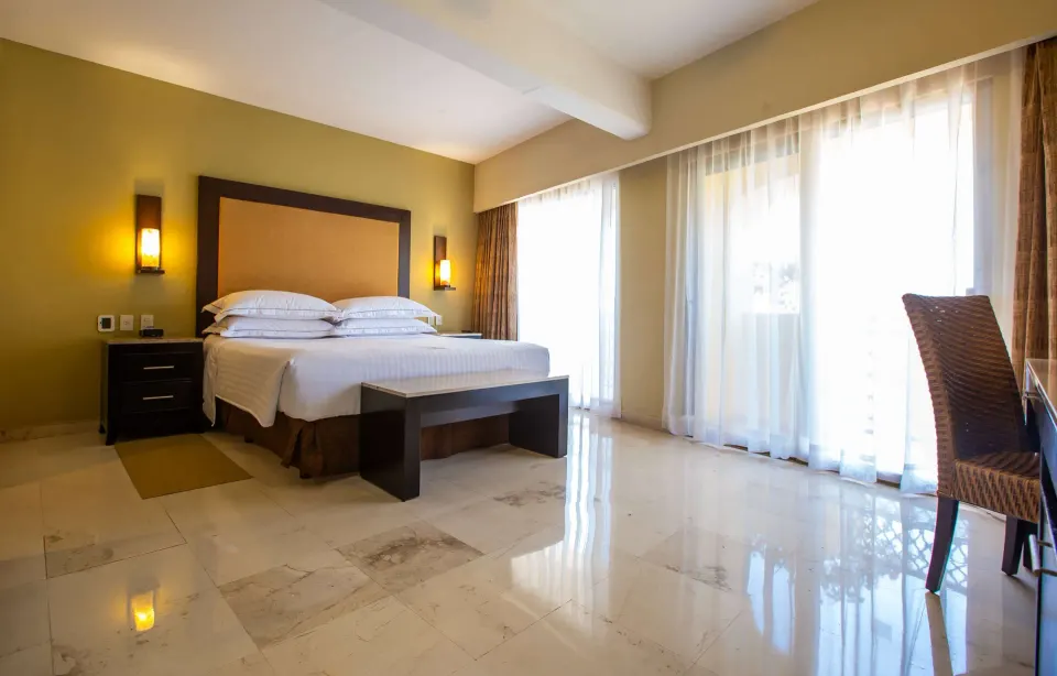 Master Suite Sea Front View bedroom with king bed and balcony doors at Barceló Puerto Vallarta.