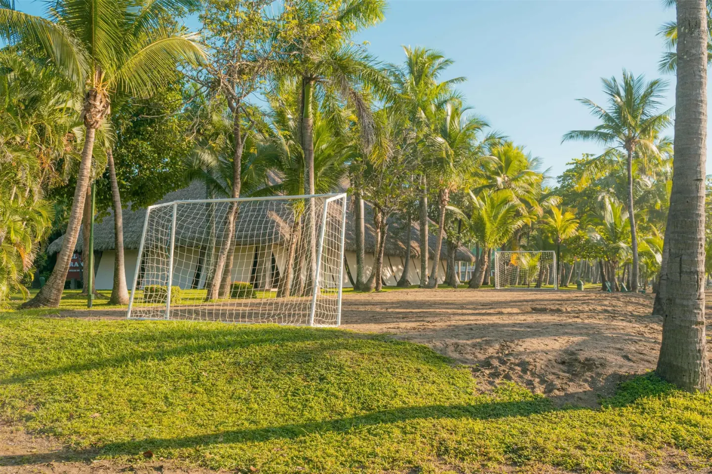 Beach soccer goals under palm trees near resort buildings at Barceló Tambor.