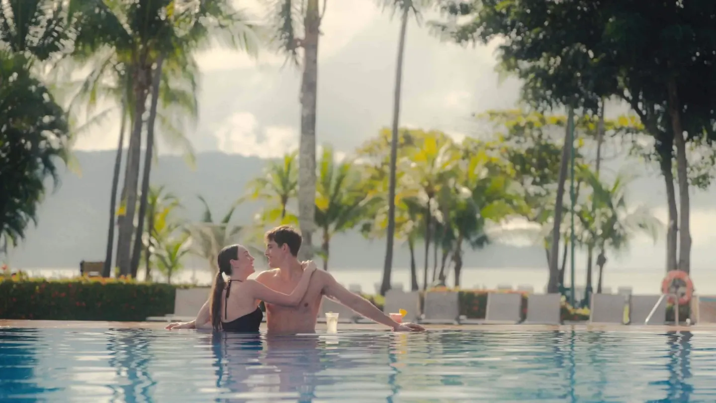 Couple relaxing in the pool with palms and water beyond at Barceló Tambor.