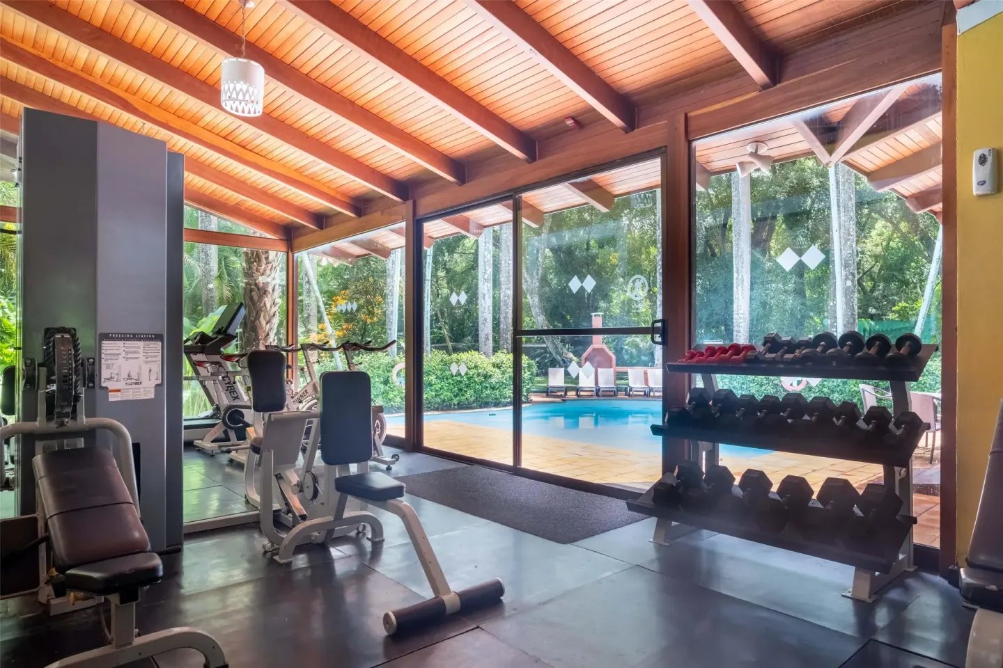 Fitness room with weights, machines, and pool views at Barceló Tambor.