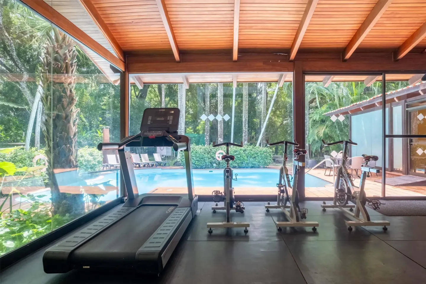 Fitness room with treadmill, exercise bikes, and pool view at Barceló Tambor.