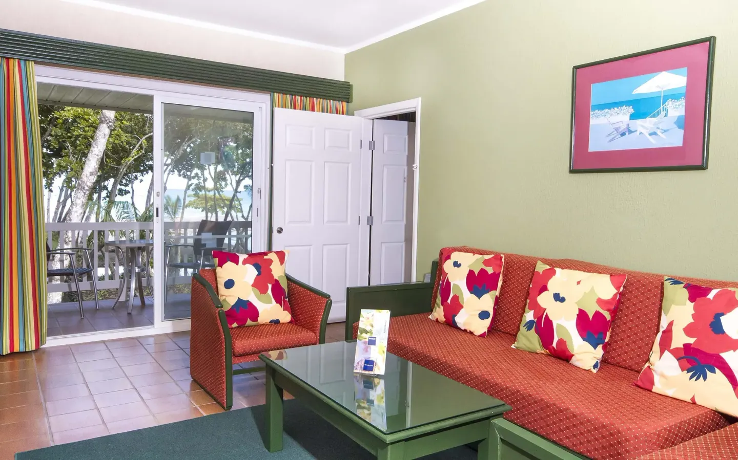 Guest room sitting area with sofa, armchair, and balcony doors at Barceló Tambor.