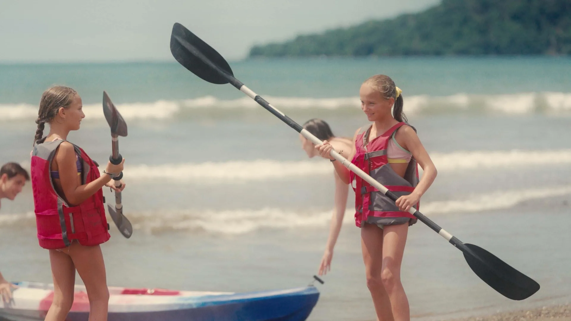 Children hold kayak paddles on the beach beside a kayak at Barceló Tambor.