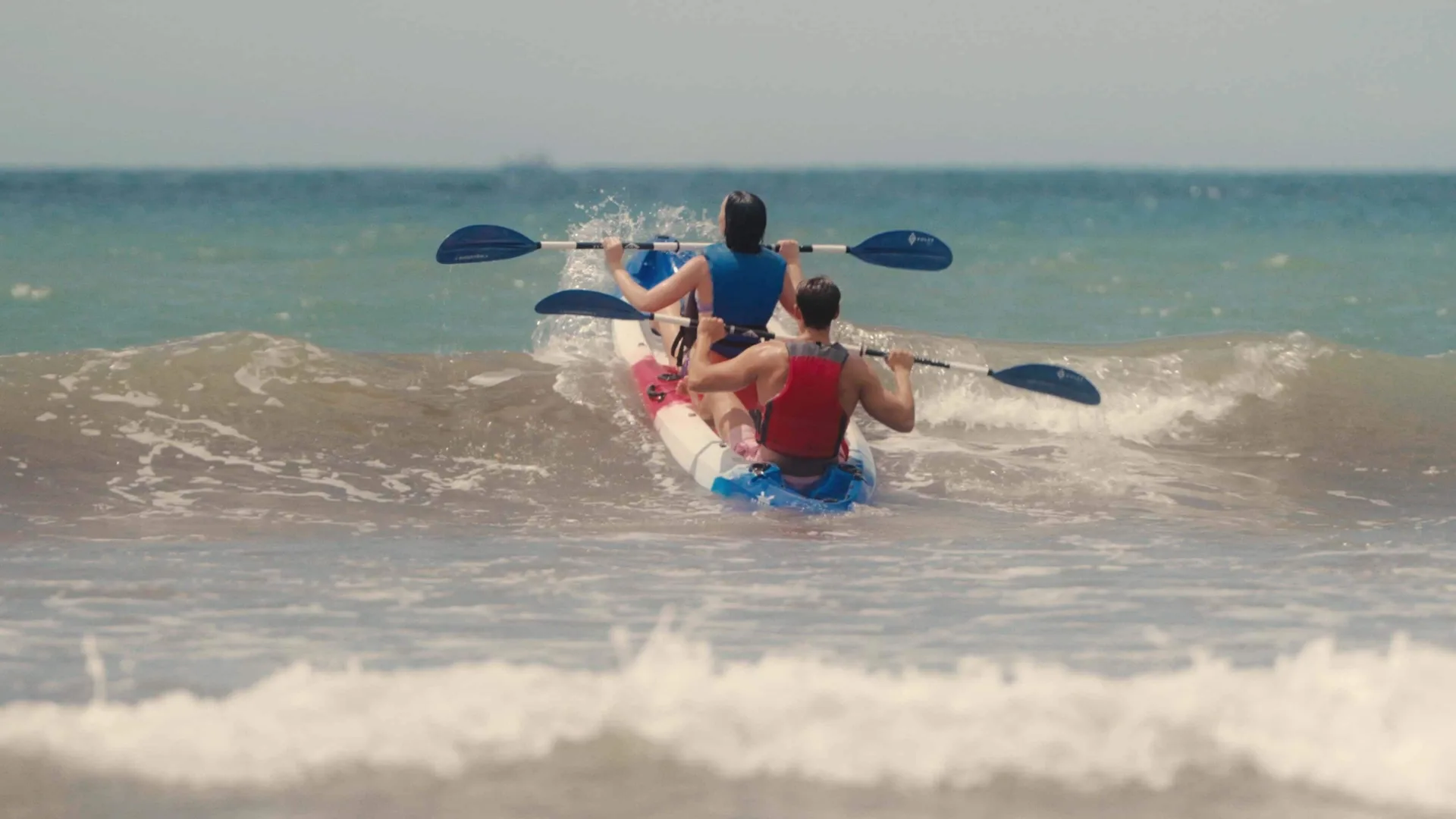 Two guests kayak through ocean waves off the beach at Barceló Tambor.