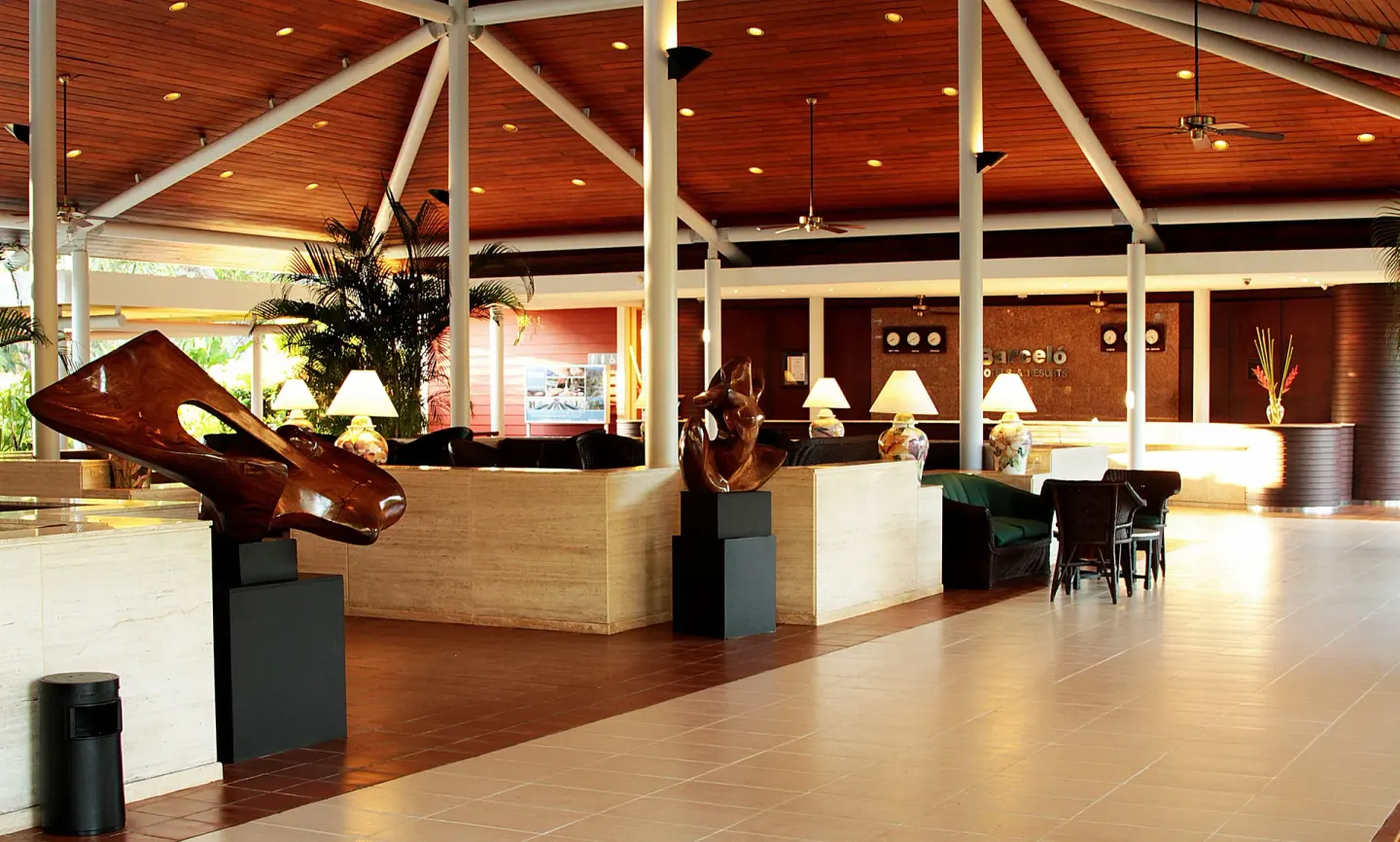 Open lobby with sculptures, seating, and reception area at Barceló Tambor.