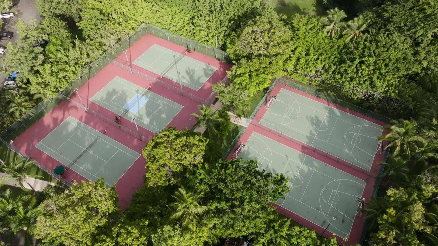 Overhead view of tennis and basketball courts in lush greenery at Barceló Tambor.