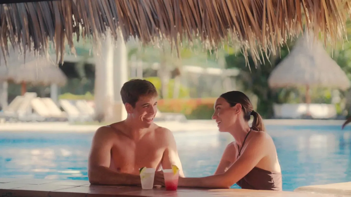 Couple sitting in the pool with tropical drinks at Barceló Tambor.