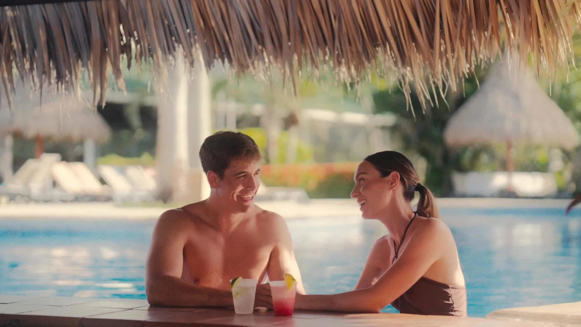 Couple sitting in the pool with tropical drinks at Barceló Tambor.