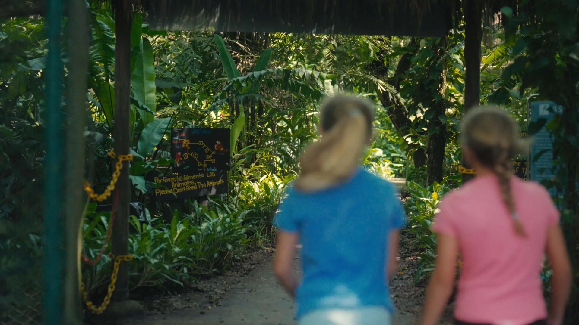 Children walk a shaded path past wildlife sanctuary signs at Barceló Tambor.