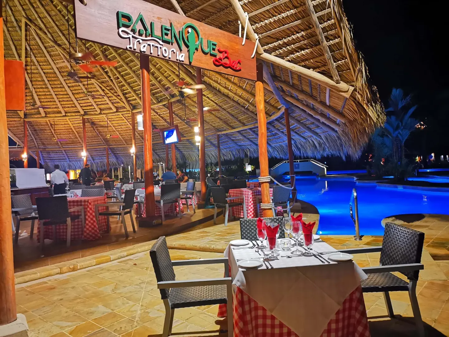 El Palenque Trattoria bar seating beside the illuminated pool at Barceló Tambor.