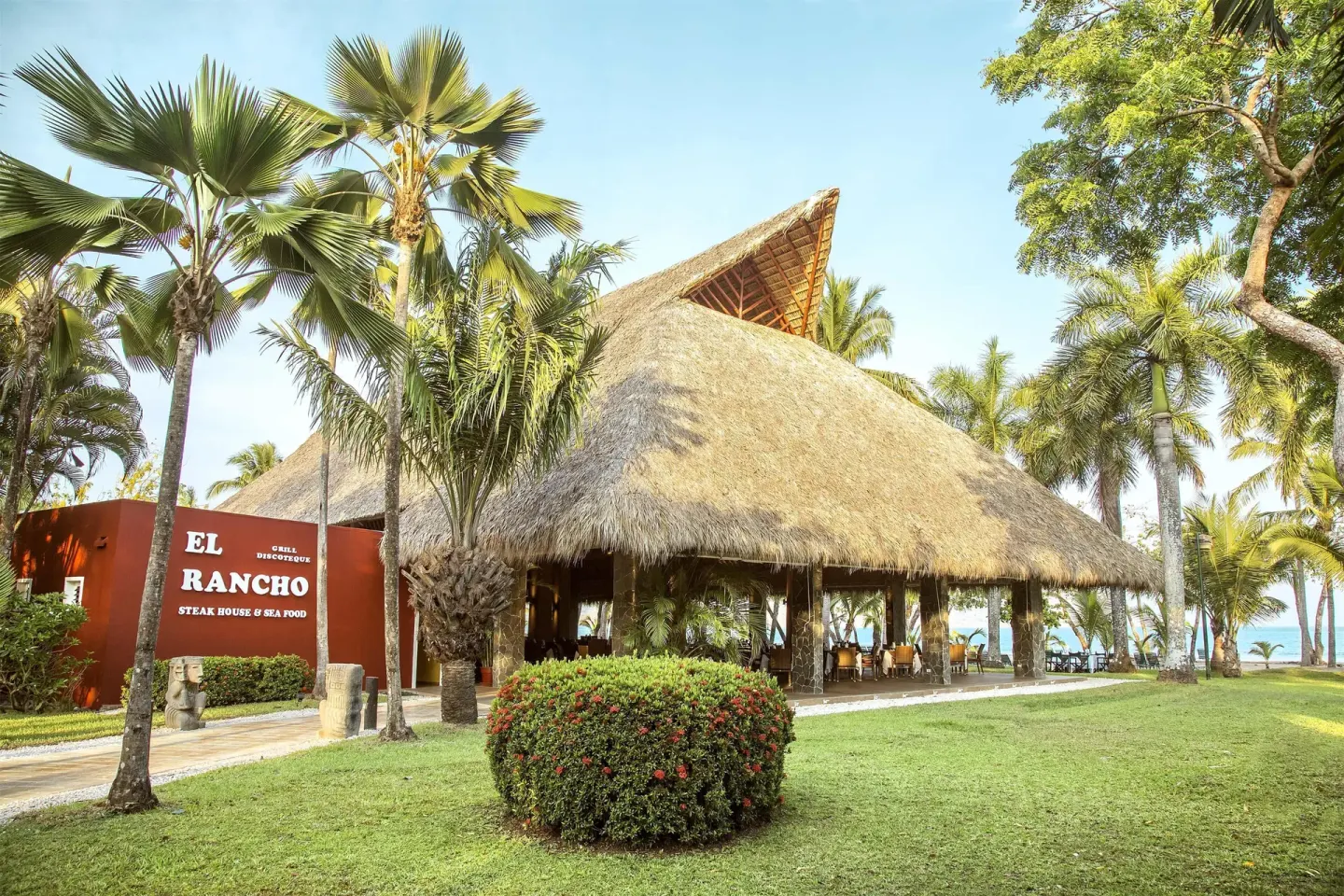 El Rancho Steak House exterior with a thatched roof and palms at Barceló Tambor.
