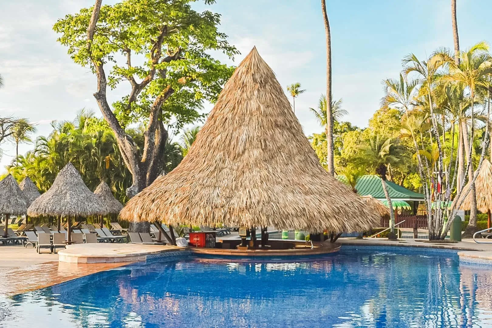 Thatched pool bar pavilion surrounded by blue water at Barceló Tambor.