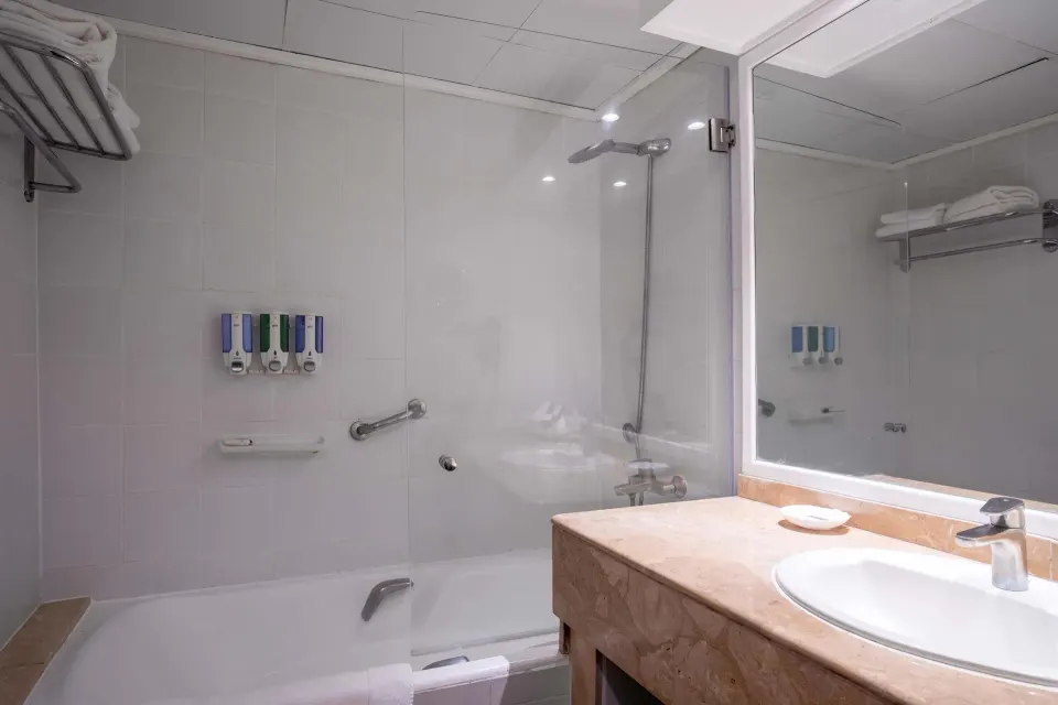 Superior Room bathroom with bathtub, shower, and vanity at Barceló Tambor.