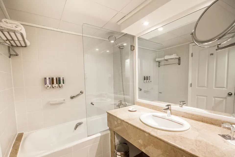 Superior Room bathroom with tub, sink, and large mirror at Barceló Tambor.