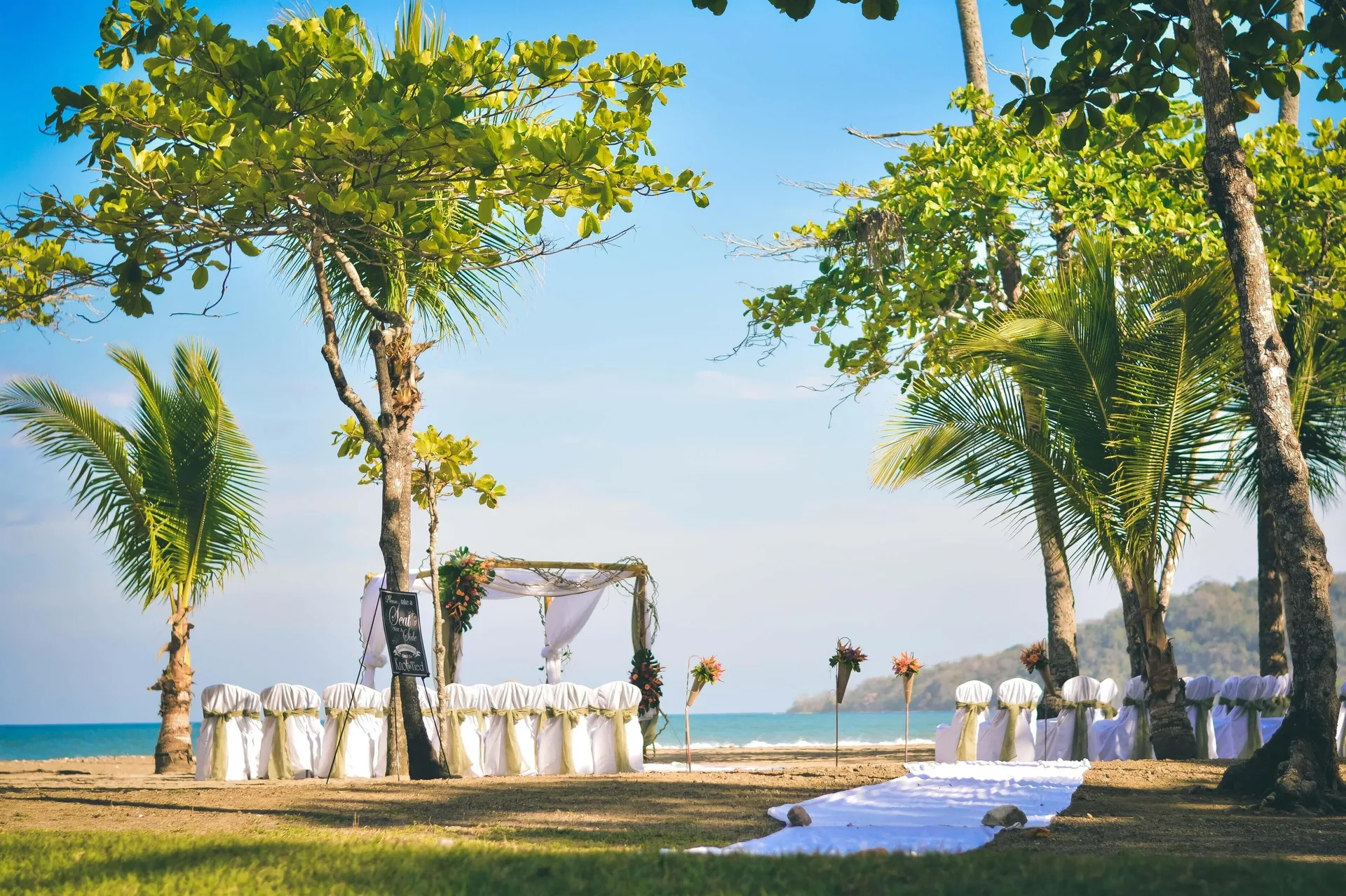 Beach wedding ceremony setup with arch and white chairs at Barceló Tambor.