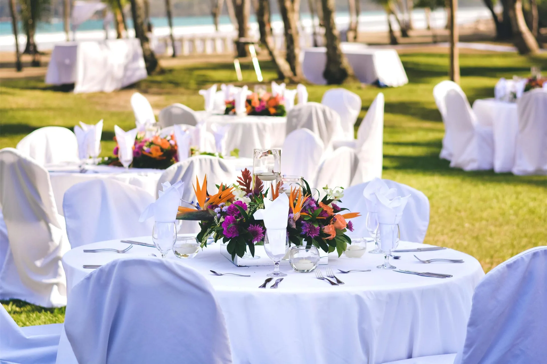 Outdoor event tables with white linens on the lawn at Barceló Tambor.