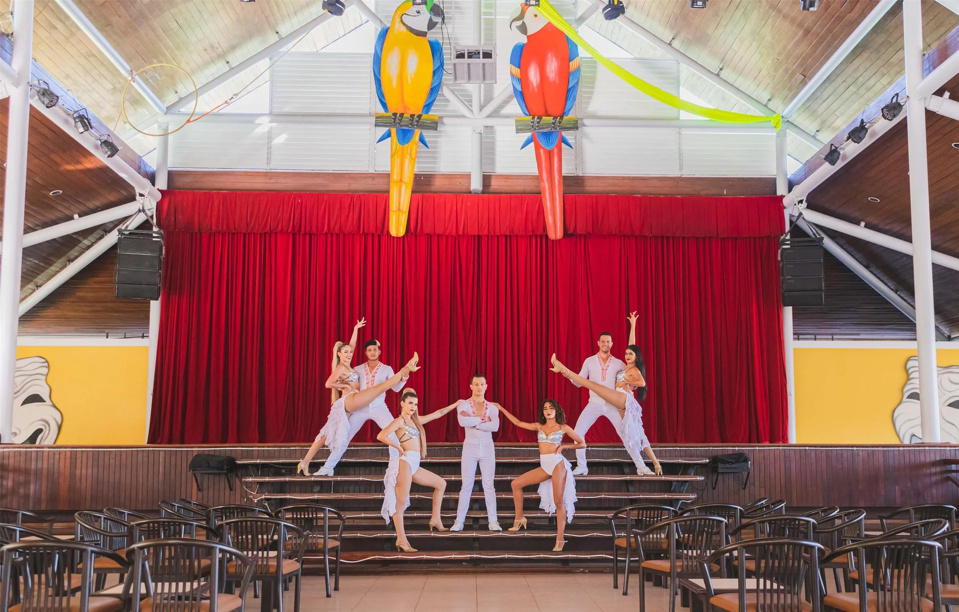 Dancers pose on a red-curtained theater stage at Barceló Tambor.