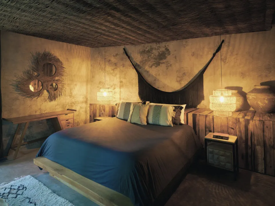 Cozy bedroom with decorative hammock and ambient lighting at BE Destination Tulum