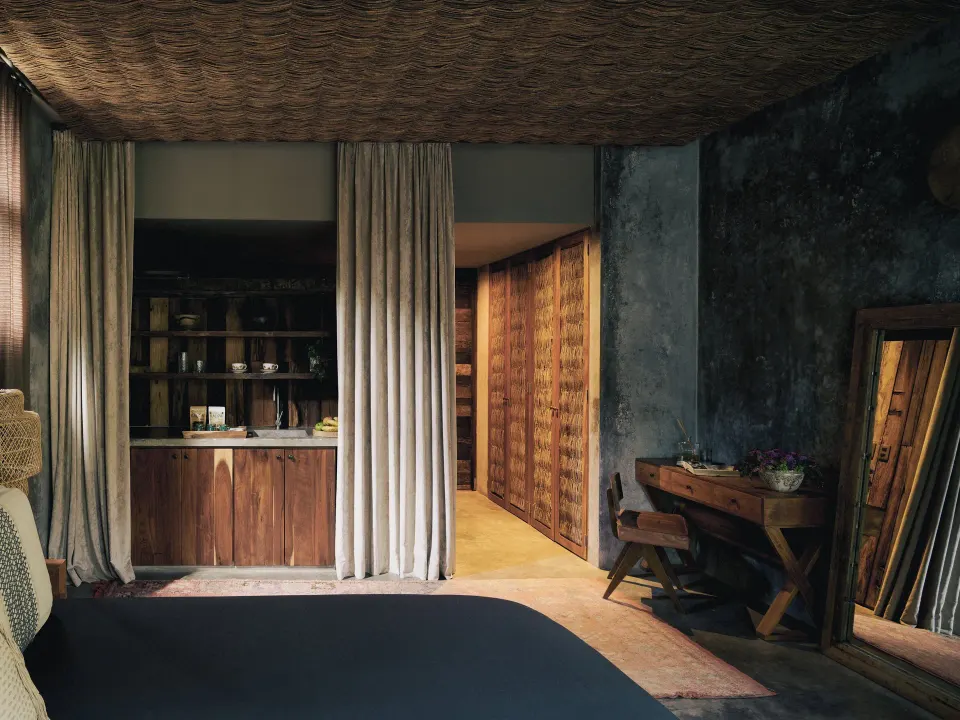 Bedroom interior with wooden cabinetry and king bed at BE Destination Tulum