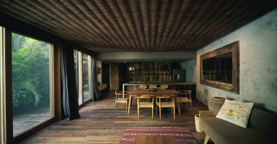 Living and dining area with wooden table and bar at BE Destination Tulum