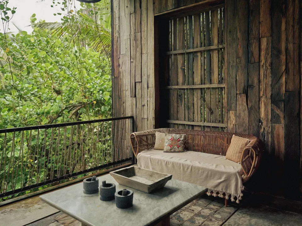 Wooden balcony seating with sofa overlooking jungle at BE Destination Tulum