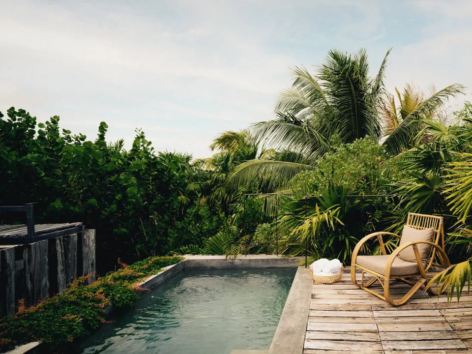 Small private plunge pool with deck chair and jungle foliage at BE Destination Tulum