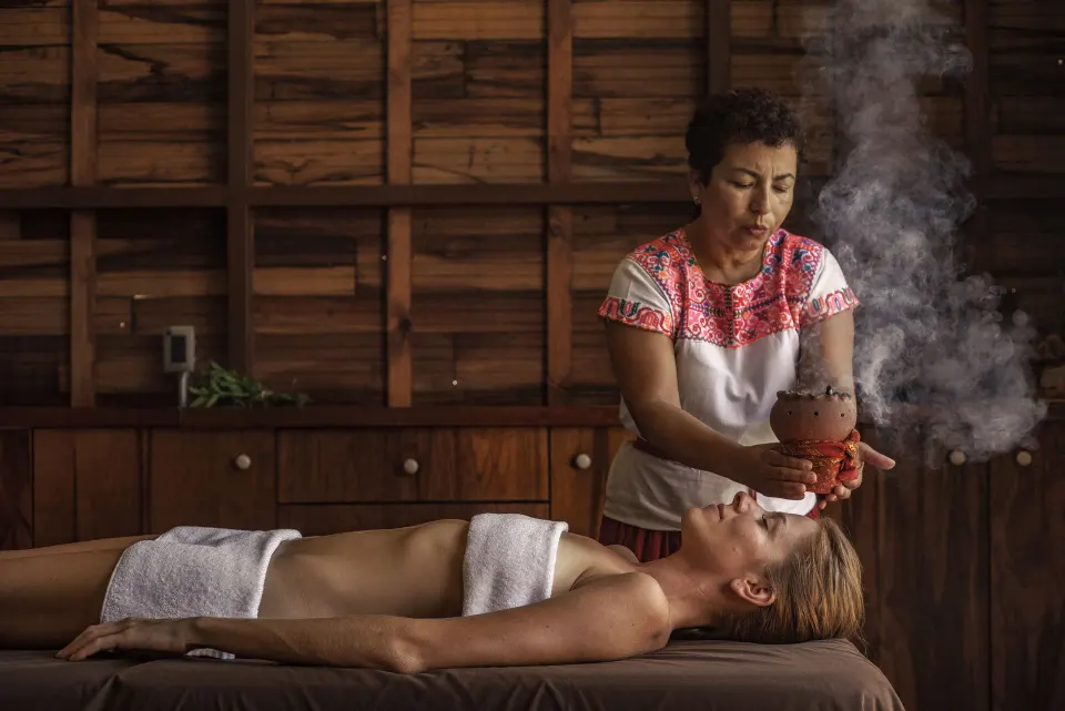 Therapist performing a ceremonial steam treatment on a guest at BE Destination Tulum