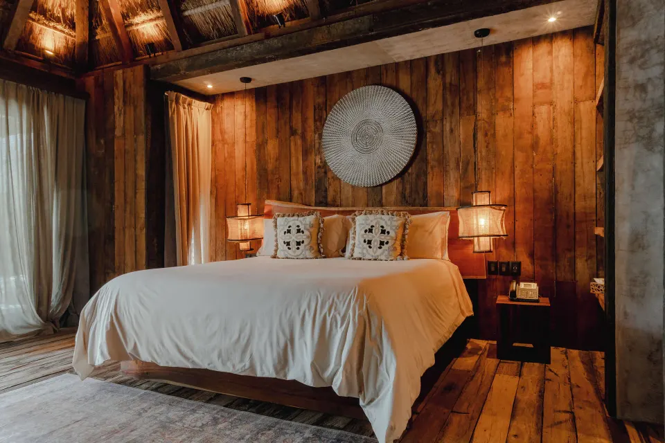 Spacious bedroom with king bed and wooden accent wall at BE Destination Tulum