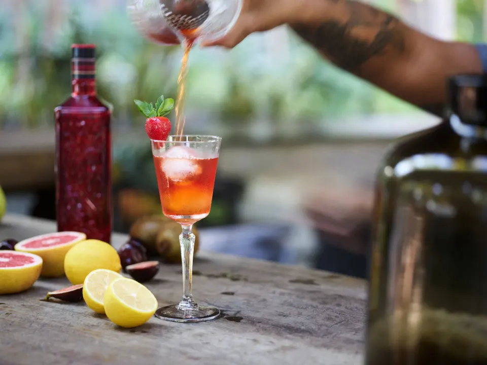 Bartender pouring a pink cocktail at BE Destination Tulum