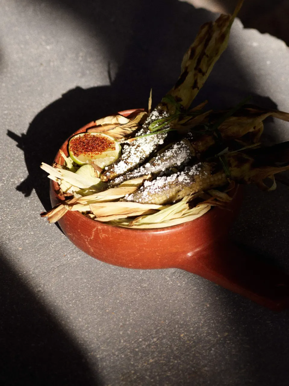 Grilled corn with fig garnish in a clay dish at BE Destination Tulum
