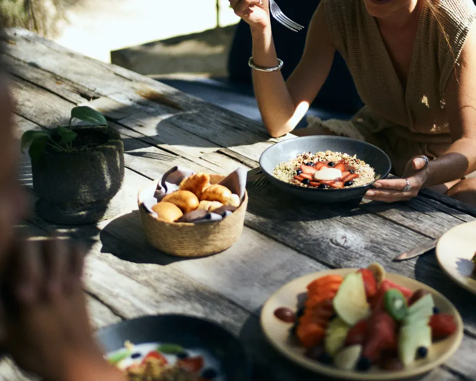 Outdoor breakfast spread on a wooden table at BE Destination Tulum