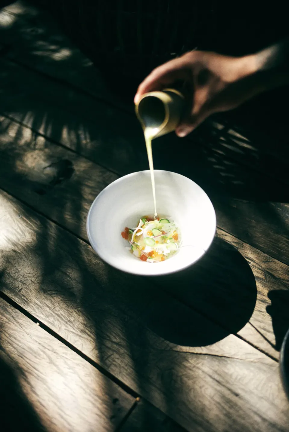 Sauce being poured over a plated appetizer at BE Destination Tulum