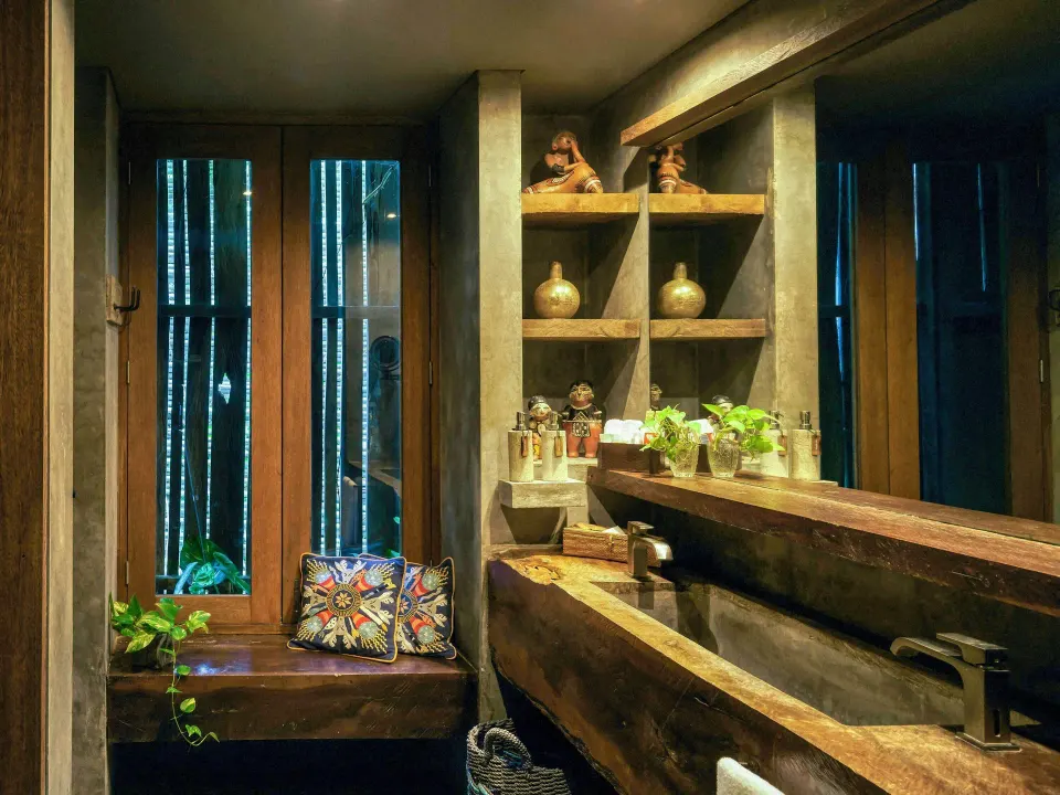 Suite bathroom with double wooden sink and decorative shelving at BE Destination Tulum