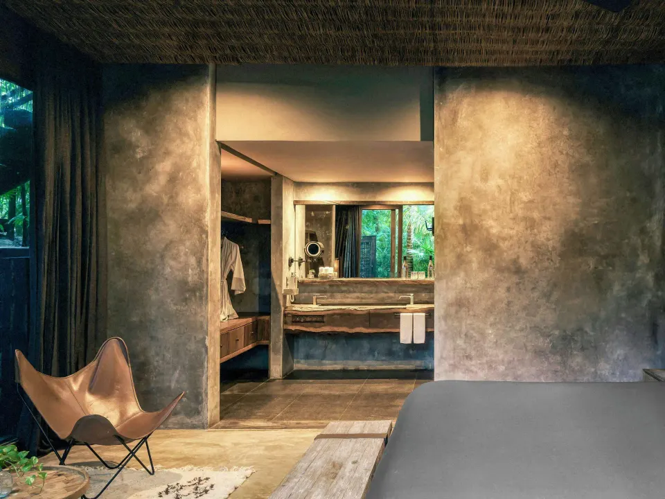 Signature Suite bedroom view toward open bathroom and vanity at BE Destination Tulum