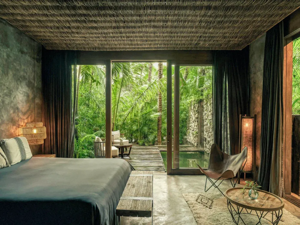 Signature Suite with plunge pool and king bed opening to lush jungle at BE Destination Tulum