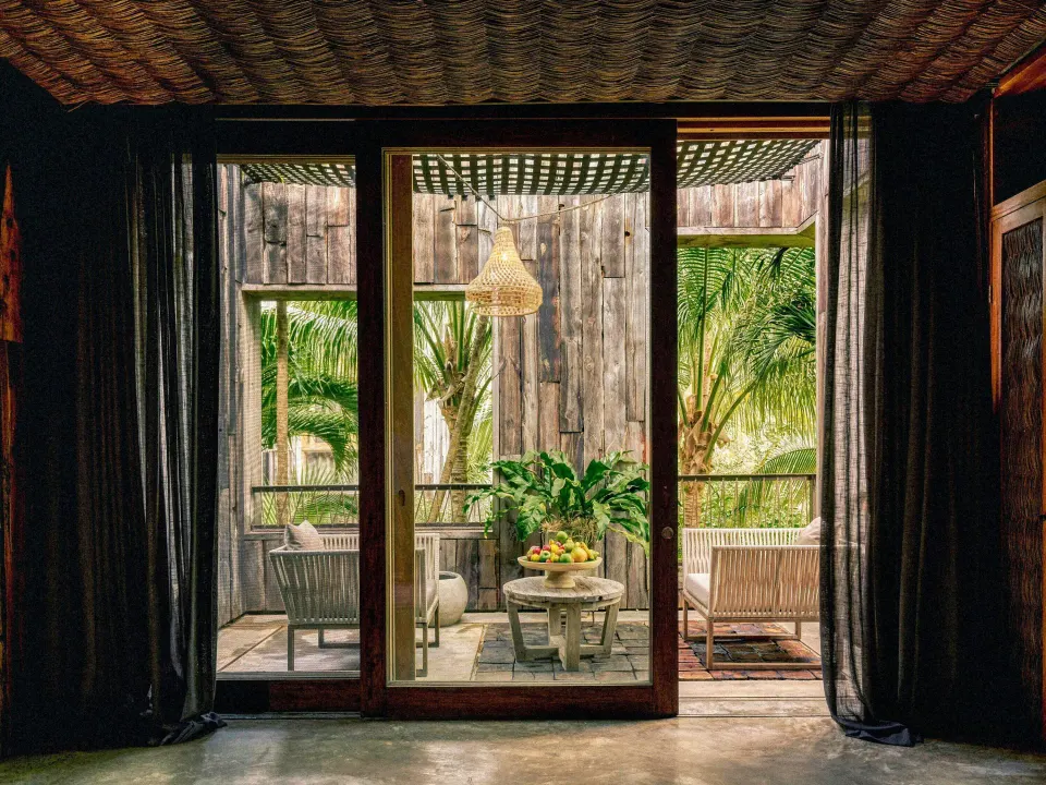 Air Suite outdoor seating area on a covered terrace visible through sliding glass doors at BE Destination Tulum.