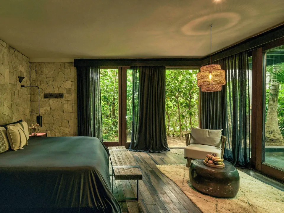 Alcove Suite bedroom with king bed and garden view at BE Destination Tulum