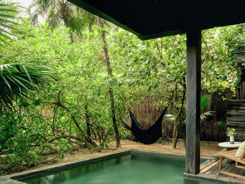 Private plunge pool and hammock surrounded by jungle foliage at BE Destination Tulum